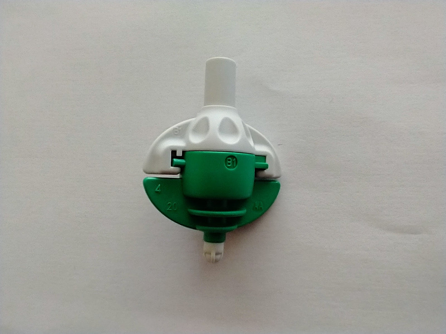 a green and white wall mounted light switch